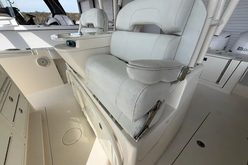Slide: The Image of 2015 Cobia 344 Center Console boat with white cushioned seating and storage compartments. - 143