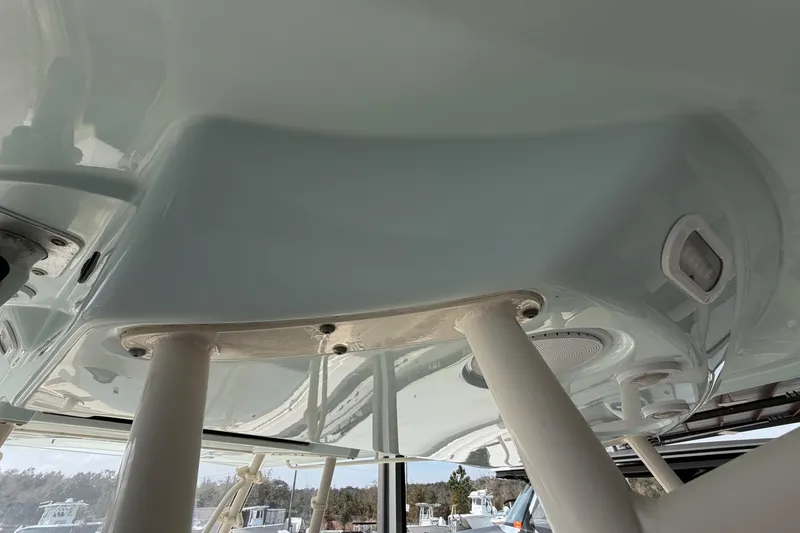 Slide: The Image of 2015 Cobia 344 Center Console boat interior with support poles and ceiling details. - 145