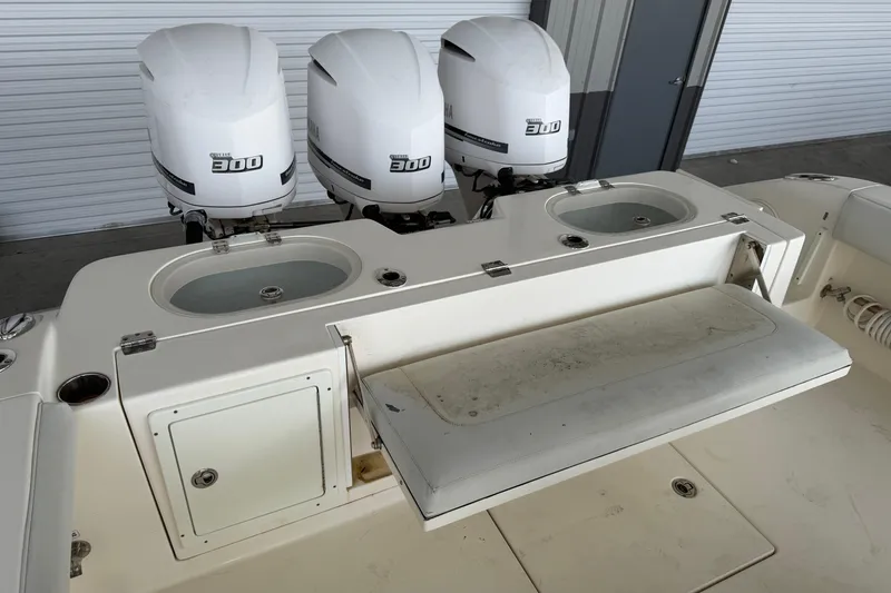 Slide: The Image of 2015 Cobia 344 Center Console with triple Yamaha 300 engines, fishing station, and storage compartments. - 148