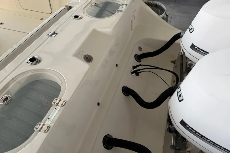 Slide: The Image of 2015 Cobia 344 Center Console boat with dual outboard engines and livewell compartments. - 151