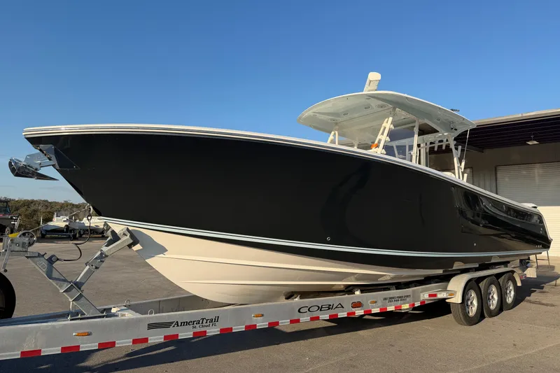 Slide: The Image of 2015 Cobia 344 Center Console boat on trailer, black hull, sunny day. - 156