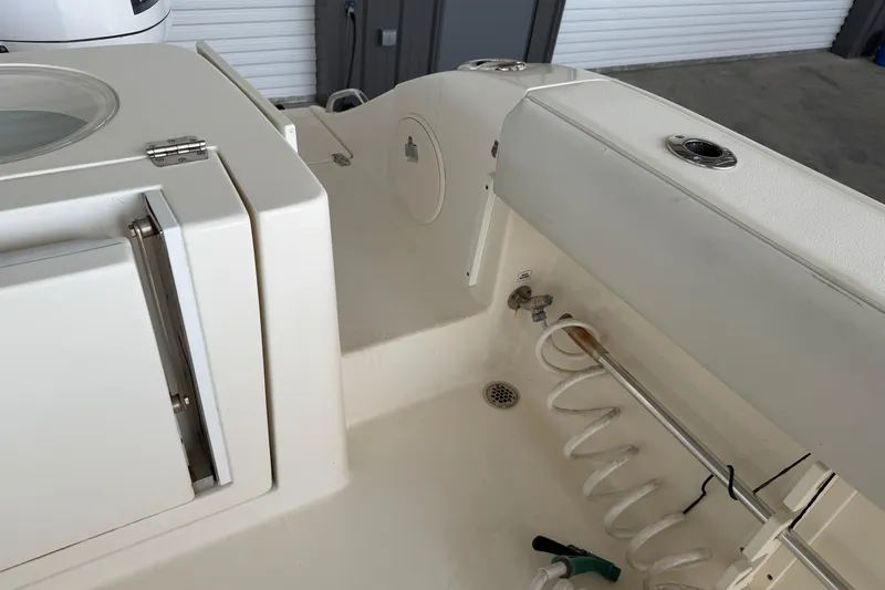 Slide: The Image of 2015 Cobia 344 Center Console boat interior with storage and hose setup. - 25