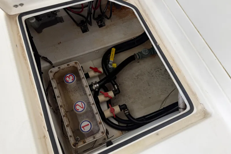 Slide: The Image of 2015 Cobia 344 Center Console boat compartment with labeled valves and wiring. - 28