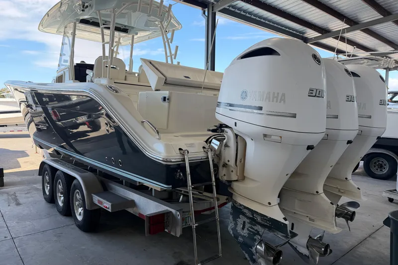 Slide: The Image of 2015 Cobia 344 Center Console boat with triple Yamaha engines on trailer. - 3