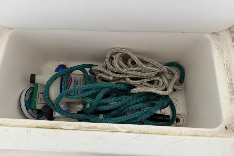 Slide: The Image of Storage compartment with ropes and supplies on a 2015 Cobia 344 Center Console boat. - 35