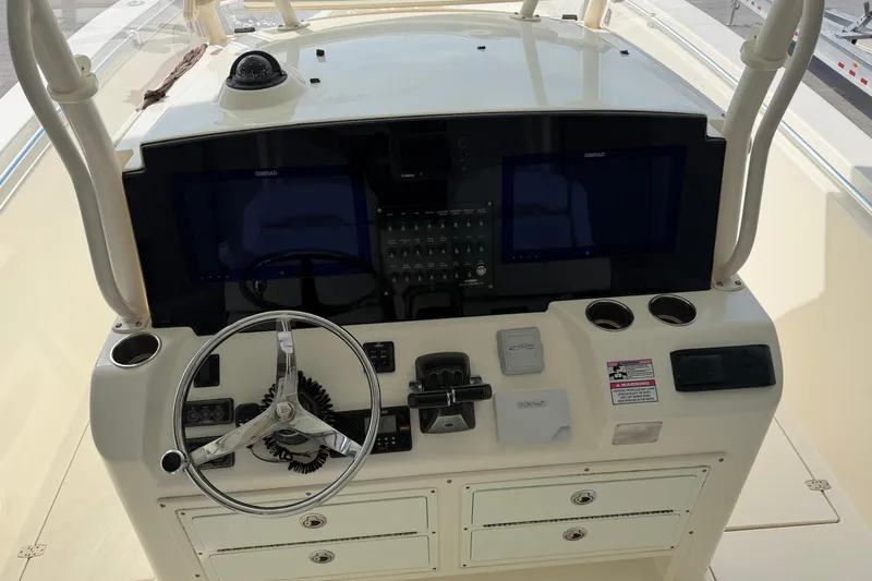 Slide: The Image of 2015 Cobia 344 Center Console helm with dual Simrad displays and steering wheel. - 40