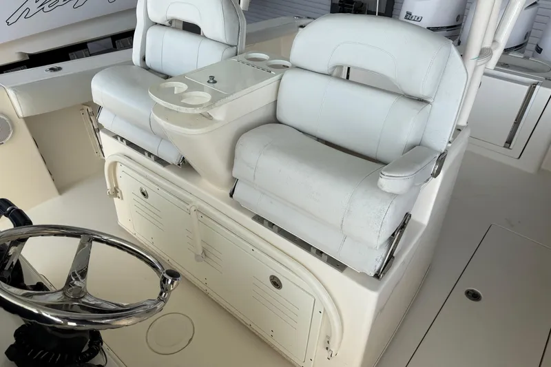 Slide: The Image of 2015 Cobia 344 Center Console boat interior with dual white captain's chairs and steering wheel. - 50