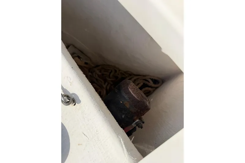 Slide: The Image of Anchor compartment of 2015 Cobia 344 Center Console with coiled rope and rusted component. - 77