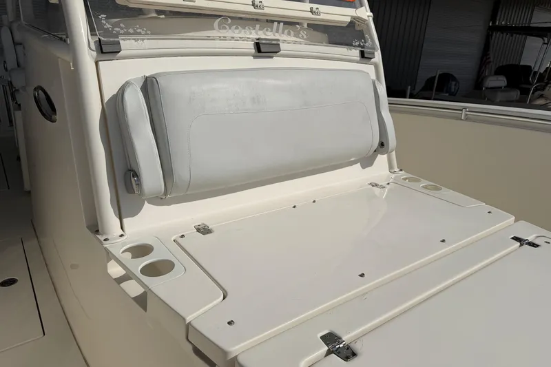 Slide: The Image of 2015 Cobia 344 Center Console boat seating area with cup holders and storage. - 86