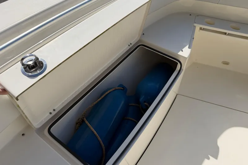 Slide: The Image of Storage compartment on 2015 Cobia 344 Center Console boat with blue fenders inside. - 90