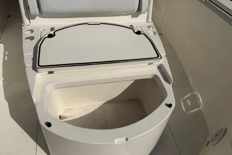 Slide: The Image of 2015 Cobia 344 Center Console boat storage compartment open, showing interior space. - 92