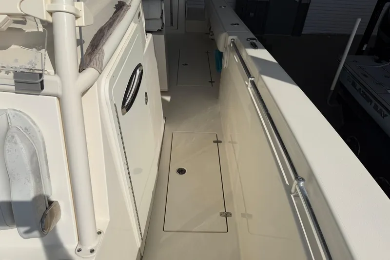 Slide: The Image of 2015 Cobia 344 Center Console boat interior with storage compartment and seating. - 96