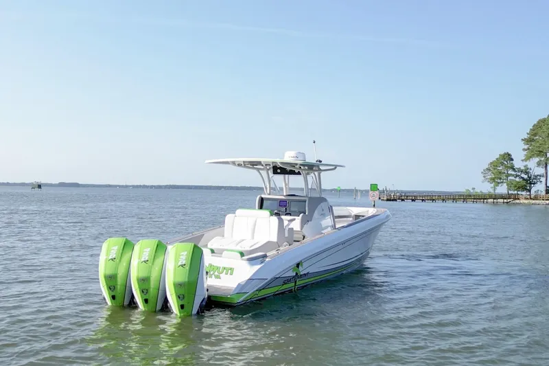 The Image of 2023 Statement 350 Open boat with triple green outboard motors on calm water. - 0