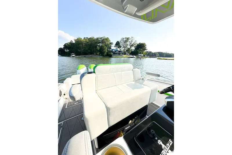 Slide: The Image of 2023 Statement 350 Open boat interior with white seating, on a scenic lake. - 11