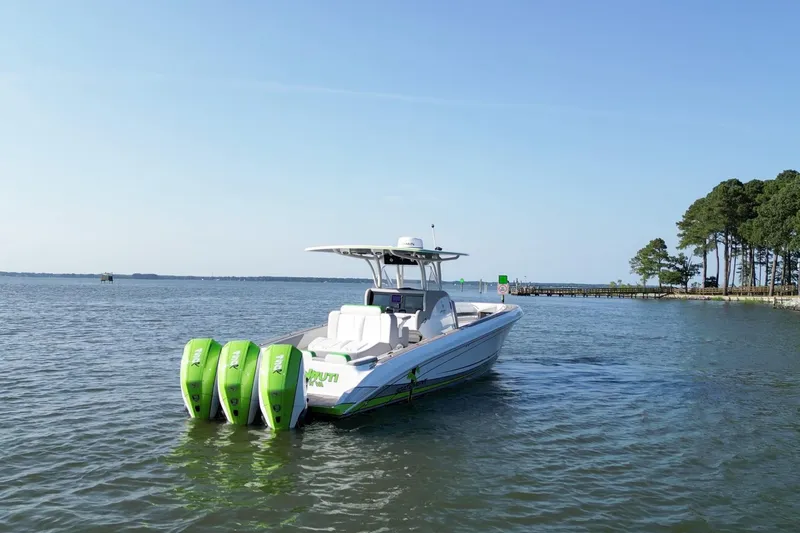 Slide: The Image of 2023 Statement 350 Open boat with triple green outboard motors on calm water. - 2