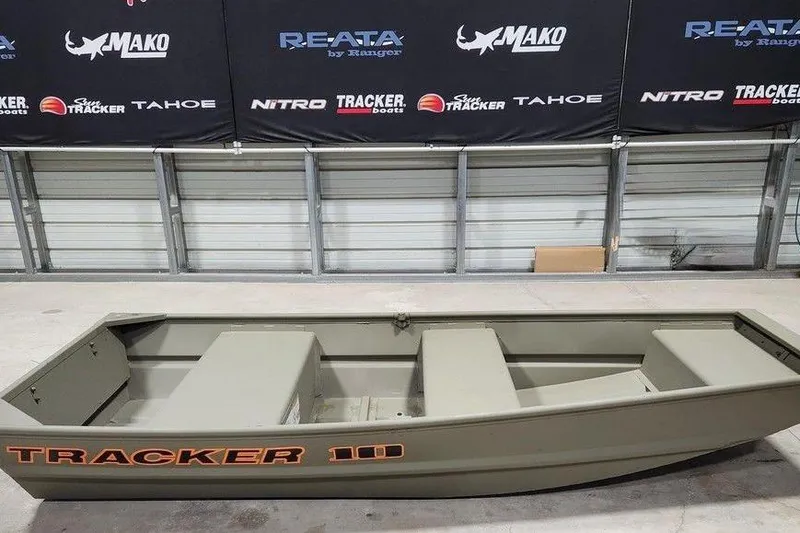 The Image of 2026 Tracker Grizzly 10 Jon boat displayed indoors with branded banners in the background. - 1