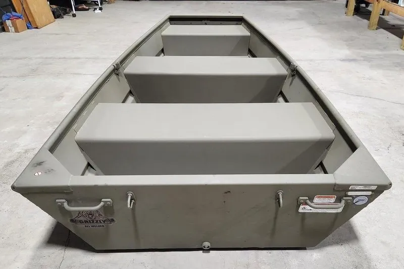 Slide: The Image of 2026 Tracker Grizzly 10 Jon boat in a garage, showcasing its sturdy design. - 3