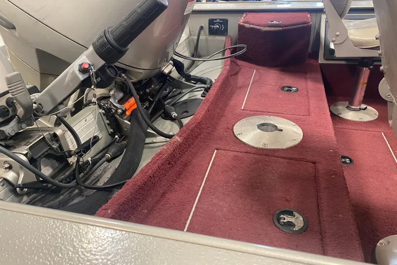 Slide: The Image of Interior of a 2001 Lund 1900 Pro-V SE boat with red carpet and seating. - 13