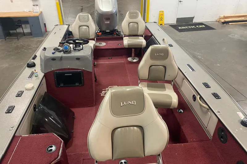 Slide: The Image of 2001 Lund 1900 Pro-V SE boat interior with red carpet and beige seats. - 4