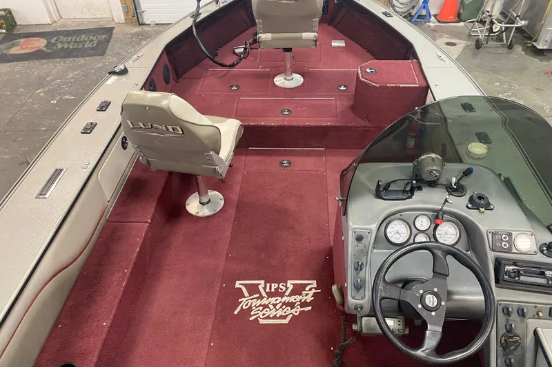 Slide: The Image of 2001 Lund 1900 Pro-V SE boat interior with red carpet and steering console. - 8
