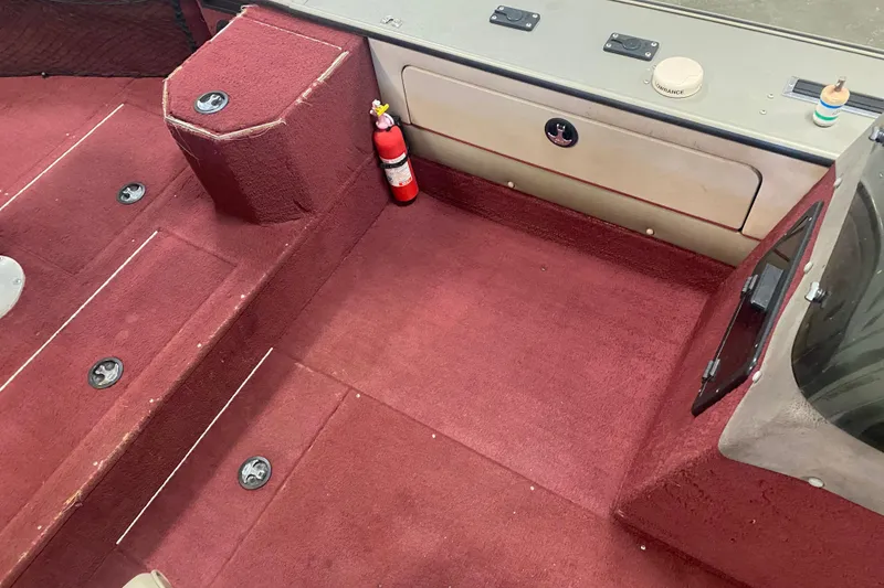 Slide: The Image of Interior of 2001 Lund 1900 Pro-V SE boat with red carpet and fire extinguisher. - 9