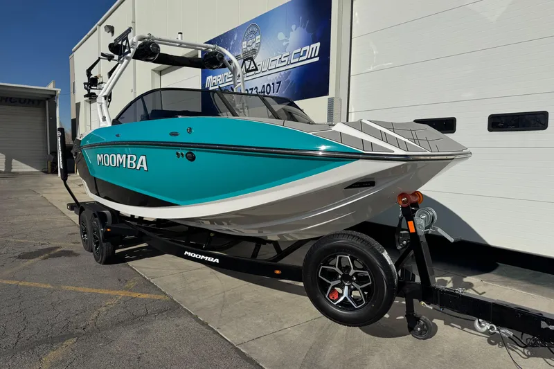 Slide: The Image of 2026 Moomba Mojo boat on trailer, parked outside a marine dealership. - 3