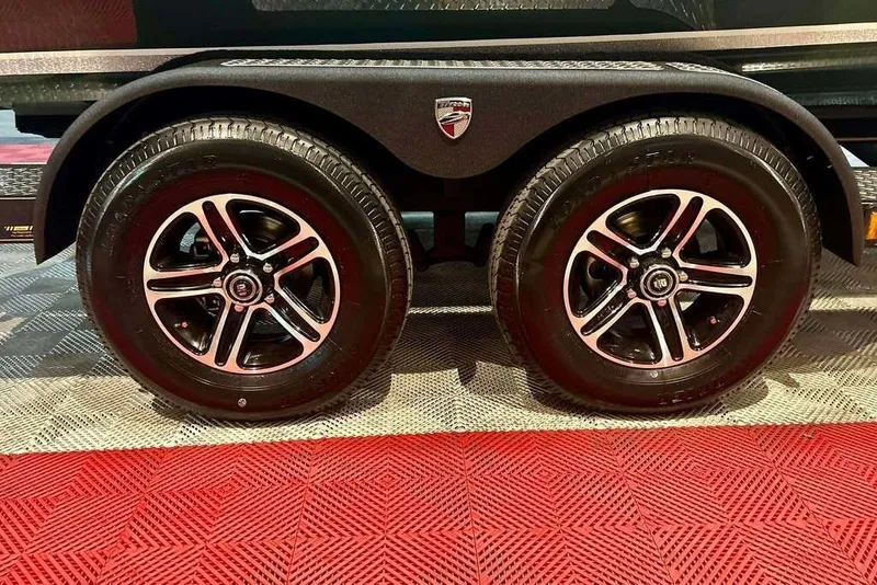 Slide: The Image of 2026 Triton 19 TrX trailer wheels on textured flooring. - 19