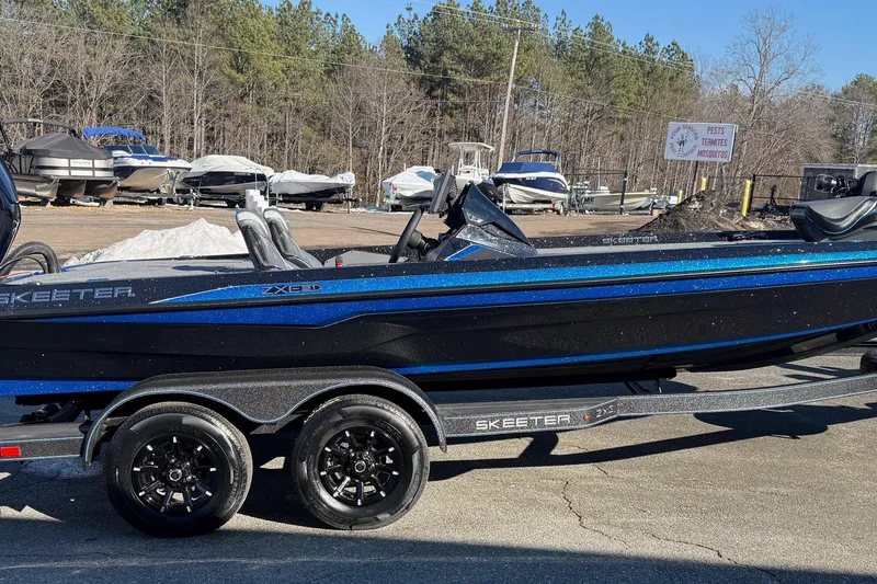 The Image of 2026 Skeeter ZXE21 boat with sleek black and blue design on a trailer. - 0