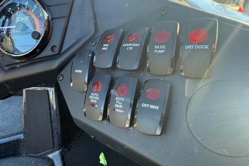 Slide: The Image of Control panel of 2026 Skeeter ZXE21 boat with various switches and gauge. - 12