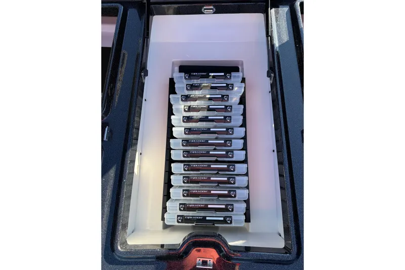 Slide: The Image of Storage compartment in 2026 Skeeter ZXE21 boat, organized with tackle boxes. - 28