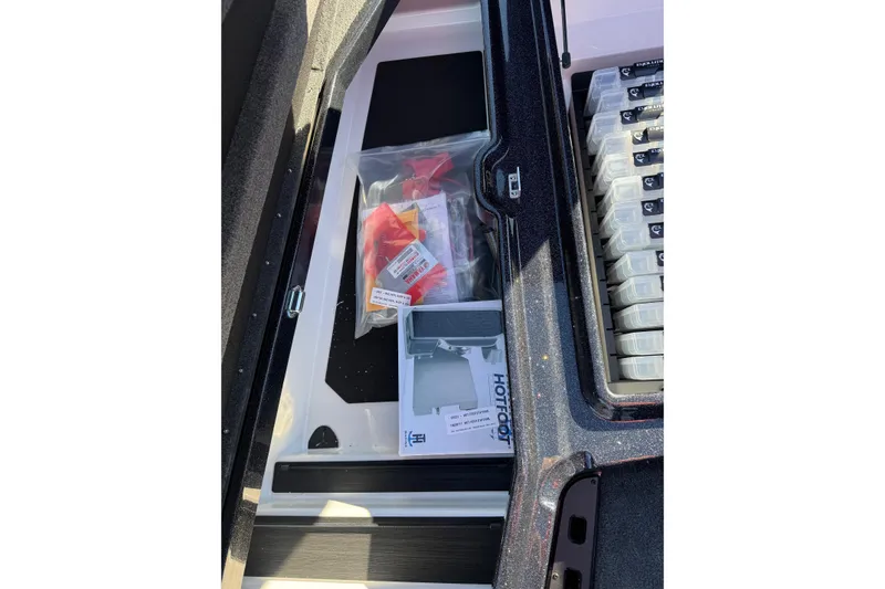 Slide: The Image of Storage compartment of 2026 Skeeter ZXE21 boat with organized gear and accessories. - 29