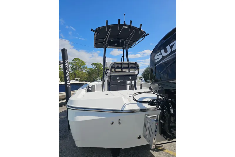 Slide: The Image of 2025 Savannah 220 IS boat with Suzuki engine, rear view, parked outdoors. - 11