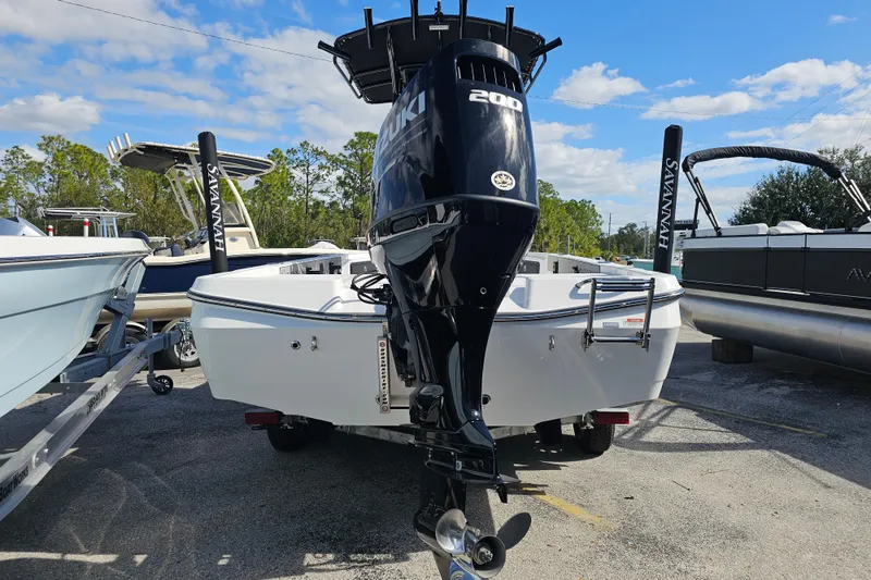 Slide: The Image of 2025 Savannah 220 IS boat with Suzuki 200 engine, parked outdoors under blue sky. - 15