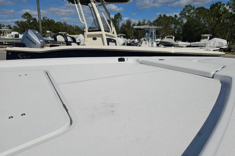 Slide: The Image of 2025 Savannah 220 IS boat deck with Honda engine, parked outdoors. - 7