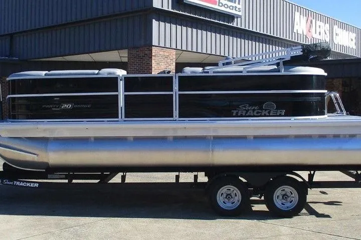 The Image of 2026 Sun Tracker Party Barge 20 DLX pontoon boat on trailer outside dealership. - 1
