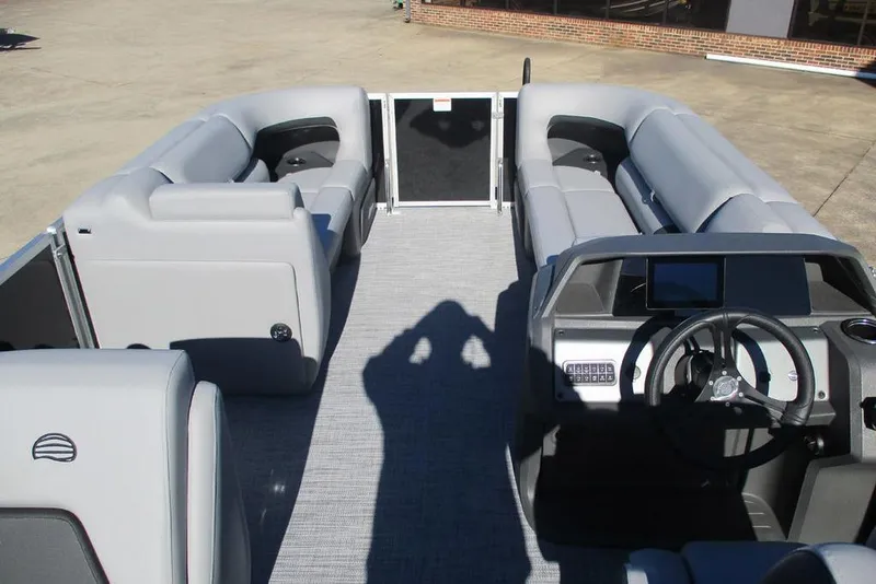 Slide: The Image of 2026 Sun Tracker Party Barge 20 DLX interior with gray seating and steering console. - 10