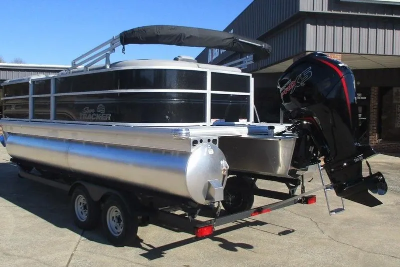 Slide: The Image of 2026 Sun Tracker Party Barge 20 DLX pontoon boat on trailer, parked outdoors. - 3