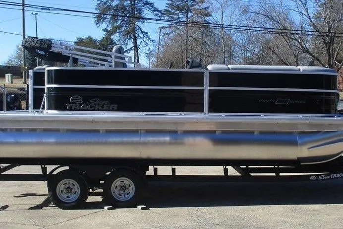 Slide: The Image of 2026 Sun Tracker Party Barge 20 DLX pontoon boat on trailer, parked outdoors. - 4