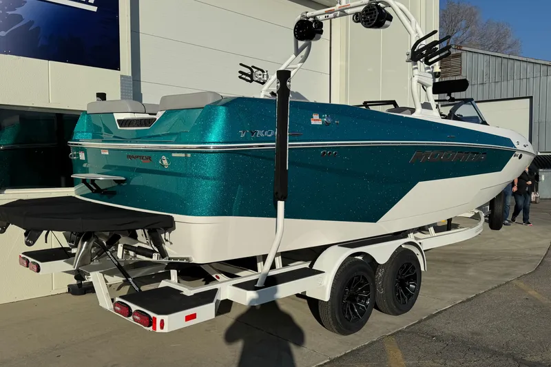 Slide: The Image of 2026 Moomba Tykon boat with teal and white design on a trailer. - 3