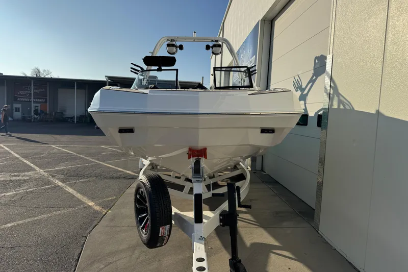 Slide: The Image of 2026 Moomba Tykon boat on trailer outside a service garage. - 6