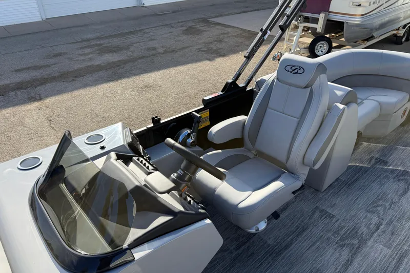 Slide: The Image of 2026 Bentley Pontoons Legacy 243 Navigator interior with captain's chair and steering console. - 15