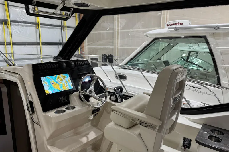 Slide: The Image of Interior of 2022 Boston Whaler 325 Conquest Pilothouse with navigation display and steering wheel. - 1
