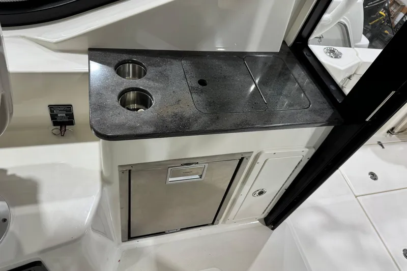 Slide: The Image of 2022 Boston Whaler 325 Conquest Pilothouse interior with sleek countertop and storage. - 16