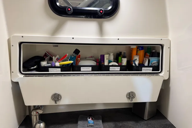 Slide: The Image of Storage compartment with toiletries on a 2022 Boston Whaler 325 Conquest Pilothouse boat. - 20