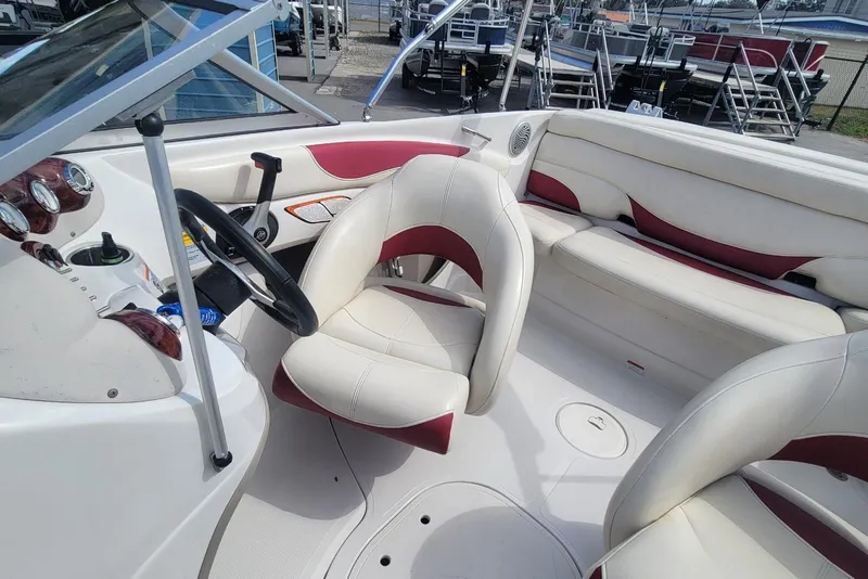 Slide: The Image of 2014 Tahoe Q7i boat interior with white and red seating, steering wheel, and dashboard. - 10
