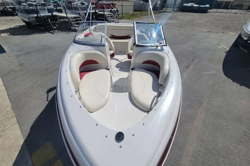 Slide: The Image of 2014 Tahoe Q7i boat with white and red seating, parked on a lot. - 6