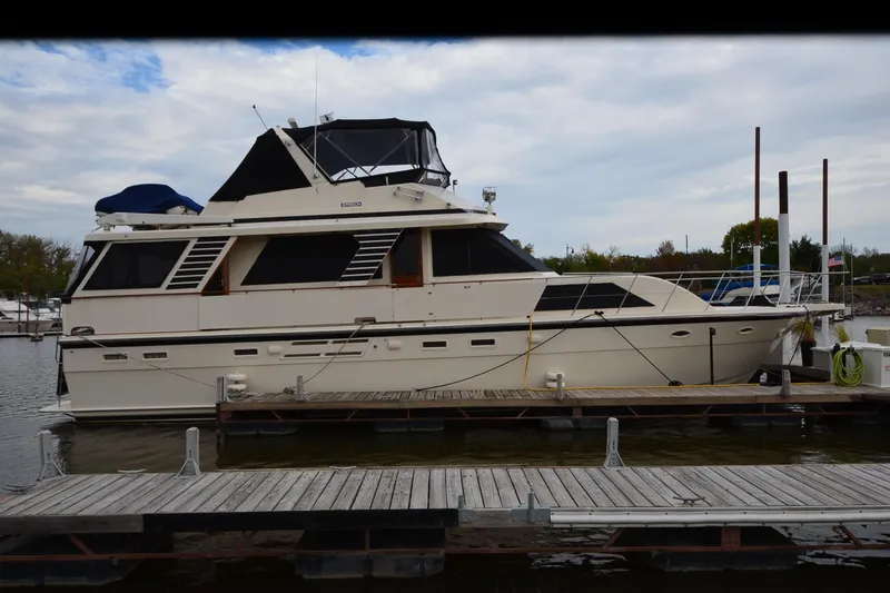 The Image of 1990 Jefferson 52 Marquessa ED yacht docked at marina under cloudy sky. - 0