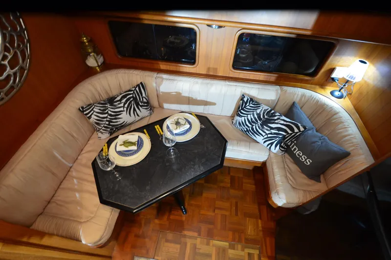 Slide: The Image of Luxurious 1990 Jefferson 52 Marquessa ED yacht interior with elegant dining setup and plush seating. - 16