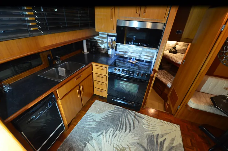 Slide: The Image of 1990 Jefferson 52 Marquessa ED yacht kitchen with modern appliances and wood cabinetry. - 17