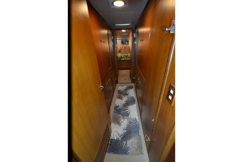 Slide: The Image of Narrow wooden hallway inside 1990 Jefferson 52 Marquessa ED yacht, featuring a patterned rug. - 25